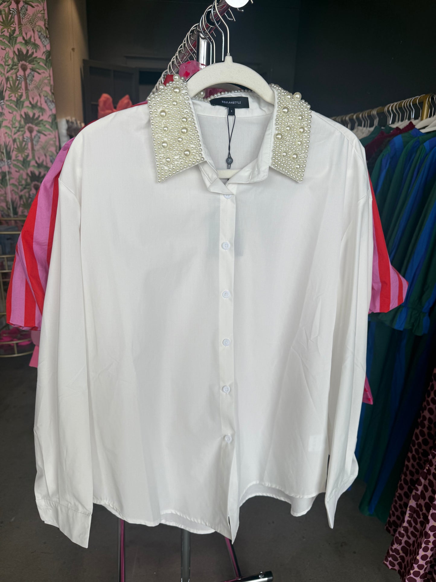 White button-up shirt with pearl-embellished collar, perfect for stylish casual or dressy occasions.