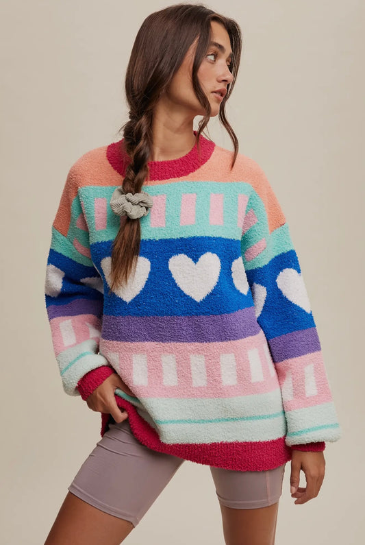 Colorful oversized sweater with hearts and stripes, soft fleece material, perfect for cozy styling.