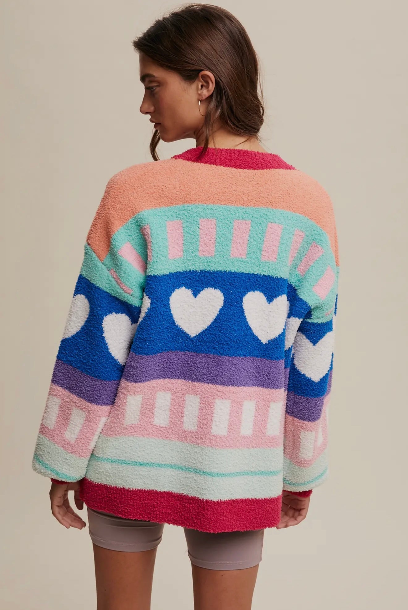 Colorful heart-patterned knit sweater in soft fabric, featuring a mix of pink, blue, and mint hues.