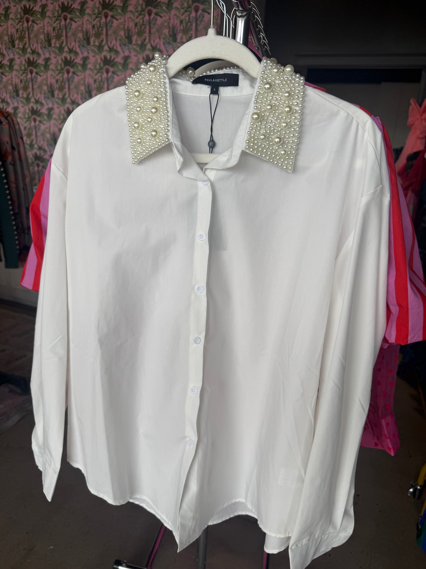 Elegant white button-up shirt with pearl-embellished collar, perfect for stylish casual wear.